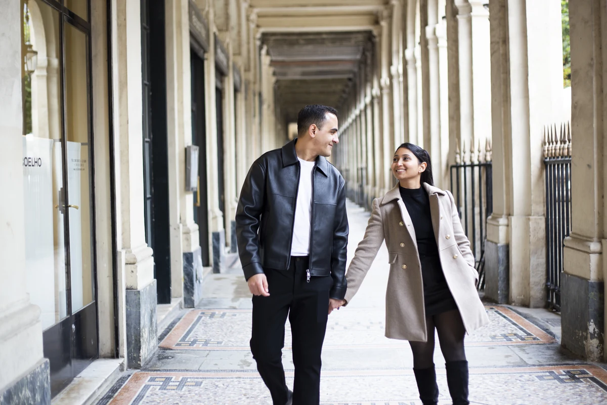 Luis y Carolin pasean de la mano bajo los soportales de París
